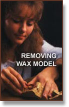 Woman carefully removing wax model from a mold